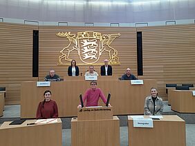 Die Prüfer für Leichte Sprache sitzen auf verschiedenen Plätzen im Landtag in Stuttgart.