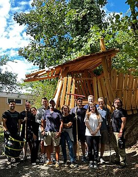Gruppe von Männern und Frauen stehen in einem Waldstück zusammen